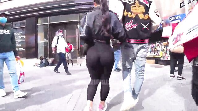 A girl with a big ass is walking on the city streets wearing see-through leggings