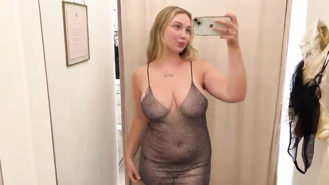 A beautiful woman trying on different transparent clothes, showcasing her stunning figure through see-through outfits