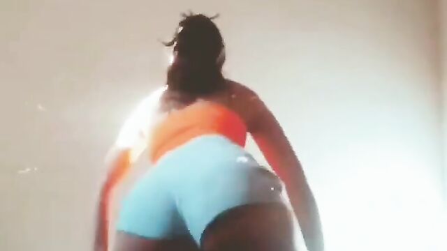 A hot brunette taking off her shorts in a sensual dance