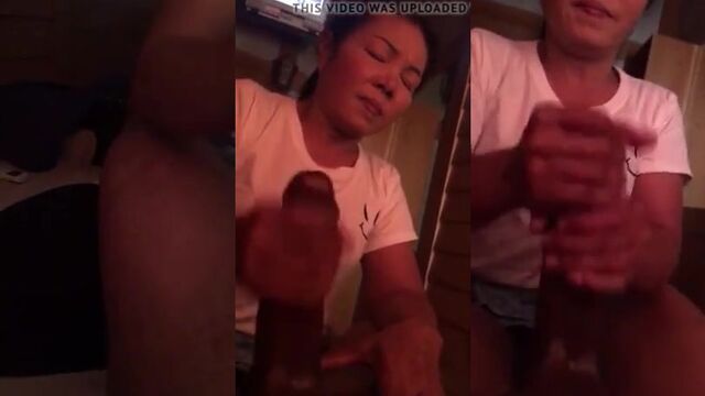 Mamasan gives a handjob to her client’s BBC at the parlor